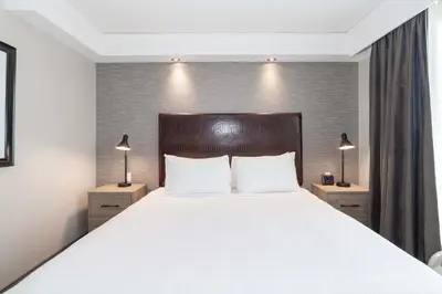 a bedroom with a large white bed with two night stands at Sandman Signature Toronto Airport Hotel in Toronto