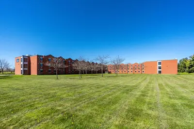 a large grass field in front of a building at Residence & Conference Centre - Welland in Welland