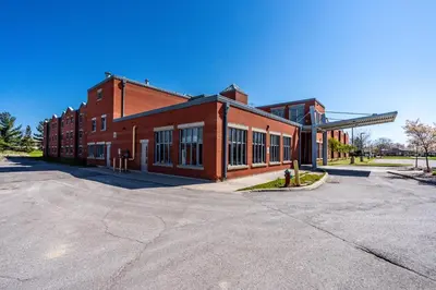 an empty parking lot in front of a brick building at Residence & Conference Centre - Welland in Welland