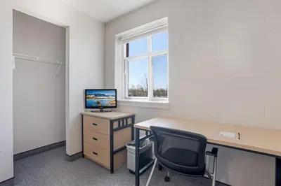 an office with a desk with a computer and a chair at Residence & Conference Centre - Welland in Welland
