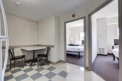 a room with a bed and a table and chairs at Residence & Conference Centre - Niagara-on-the-Lake in Niagara on the Lake