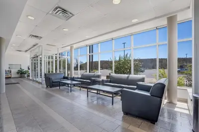 a waiting room with couches and tables and large windows at Residence & Conference Centre - Niagara-on-the-Lake in Niagara on the Lake