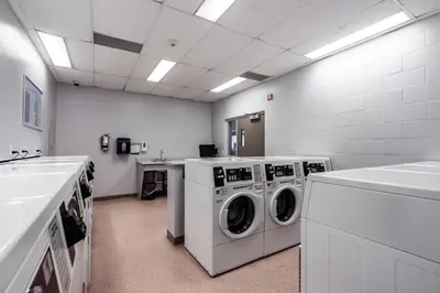 a laundry room with washing machines and a sink at Residence & Conference Centre - Niagara-on-the-Lake in Niagara on the Lake