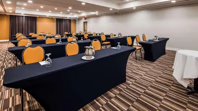 a conference room with rows of tables and chairs at Best Western Premier Toronto Airport Carlingview Hotel in Toronto