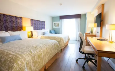 a hotel room with two beds and a desk at Best Western Premier Toronto Airport Carlingview Hotel in Toronto
