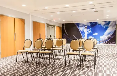 a group of chairs in a room with a mural at Best Western Premier Toronto Airport Carlingview Hotel in Toronto