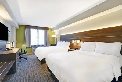 a hotel room with two beds and a flat screen tv at Holiday Inn Express Whitby Oshawa by IHG in Whitby