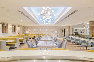 a restaurant with tables and chairs and a chandelier at The Yorkville Royal Sonesta Hotel Toronto in Toronto