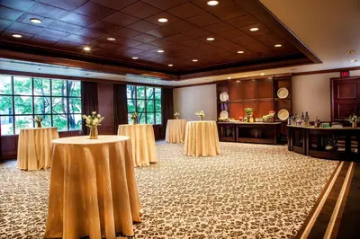a banquet room with two tables with flowers on them at The Yorkville Royal Sonesta Hotel Toronto in Toronto