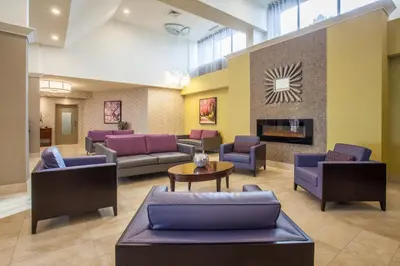 a lobby with couches and chairs and a fireplace at Holiday Inn Toronto International Airport by IHG in Toronto