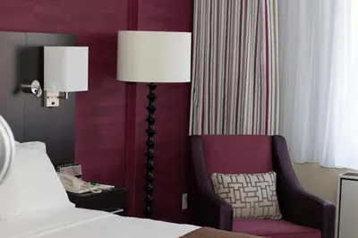a bedroom with a bed and a chair and a lamp at Holiday Inn Toronto International Airport by IHG in Toronto