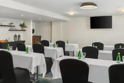 a conference room with white tables and black chairs at Holiday Inn Oakville Centre by IHG in Oakville