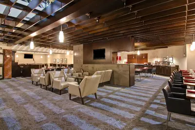 a restaurant with chairs and a bar in a room at Holiday Inn Oakville Centre by IHG in Oakville