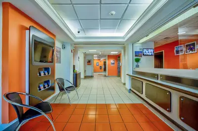 a corridor of a hospital with chairs and a tv at Motel 6-Burlington, ON - Toronto West - Oakville in Burlington