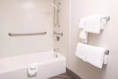 a bathroom with white towels and a bath tub at Motel 6-Brampton, ON - Toronto in Brampton