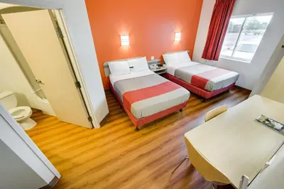 a hotel room with two beds and a table at Motel 6-Brampton, ON - Toronto in Brampton