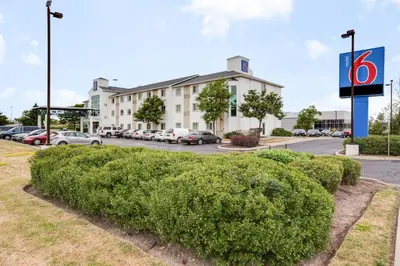 a hedge in front of a building with a parking lot at Motel 6-Brampton, ON - Toronto in Brampton