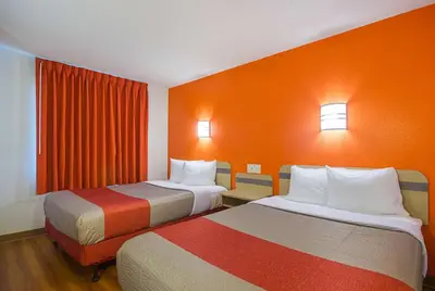 two beds in a room with orange walls at Motel 6-Whitby, ON - Toronto East in Whitby