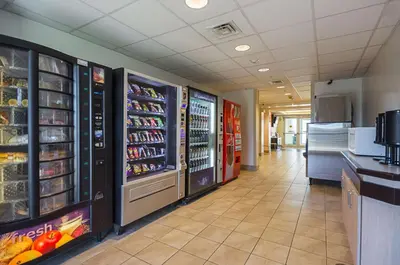 a grocery store aisle with refrigerators and shelves of food at Motel 6-Whitby, ON - Toronto East in Whitby