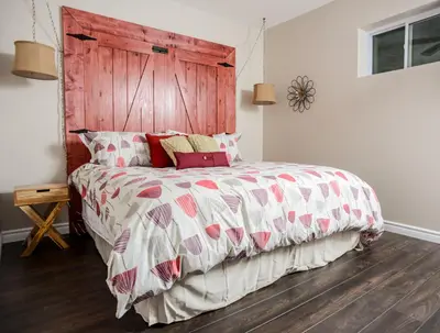 a bedroom with a large bed with a wooden headboard at The Village Suites in Wellington