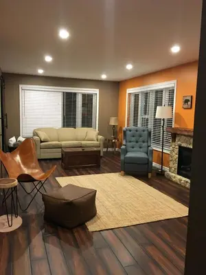 a living room with a couch and chairs and a fireplace at The Village Suites in Wellington