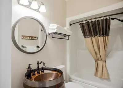 a bathroom with a sink and a mirror at The Village Suites in Wellington