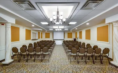 a room with a bunch of chairs and a screen at Monte Carlo Inn Barrie - Newly Renovated in Barrie
