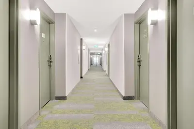 a corridor of an empty hallway with green doors at Spark By Hilton Toronto Markham in Markham