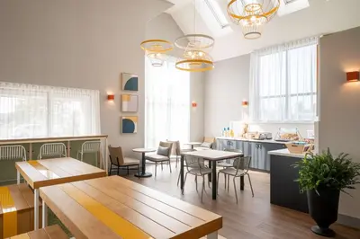 a restaurant with tables and chairs and a kitchen at Spark By Hilton Toronto Markham in Markham