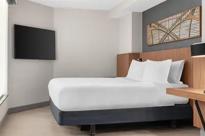a hotel room with a bed and a flat screen tv at Hilton Garden Inn Toronto Airport in Mississauga