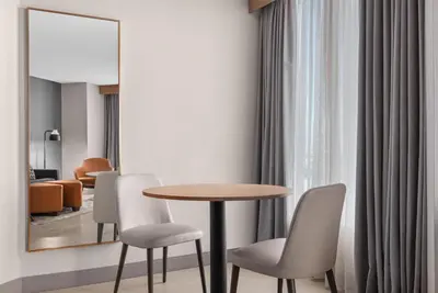 a dining room with a table and chairs and a mirror at Hilton Garden Inn Toronto Airport in Mississauga