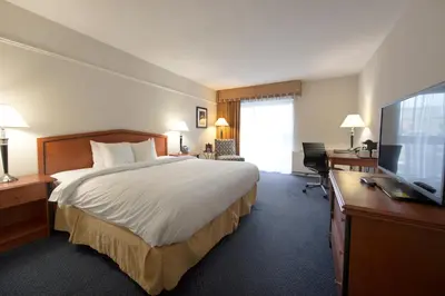 a hotel room with a bed and a desk and a television at Toronto Don Valley Hotel and Suites in Toronto