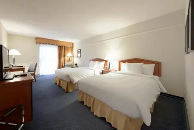 a hotel room with two beds and a television at Toronto Don Valley Hotel and Suites in Toronto