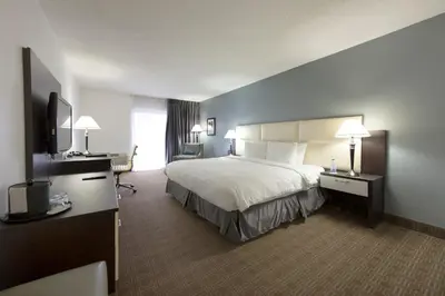 a hotel room with a bed and a flat screen tv at Toronto Don Valley Hotel and Suites in Toronto