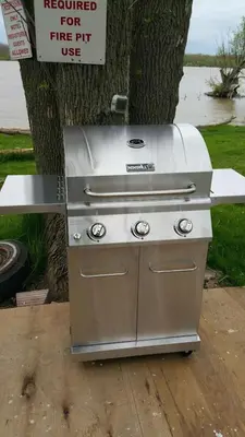 a stainless steel grill sitting next to a tree at Riverview Motel in Dunnville