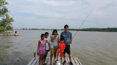 a family standing on a dock with a fishing pole at Riverview Motel in Dunnville