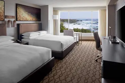 a hotel room with two beds and a desk at Niagara Falls Marriott Fallsview Hotel & Spa in Niagara Falls