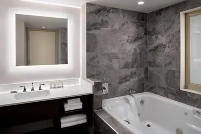 a bathroom with a tub and a sink and a mirror at Niagara Falls Marriott Fallsview Hotel & Spa in Niagara Falls