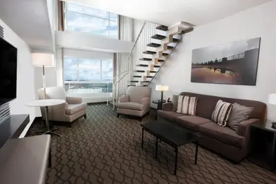 a living room with a couch and a staircase at Niagara Falls Marriott Fallsview Hotel & Spa in Niagara Falls