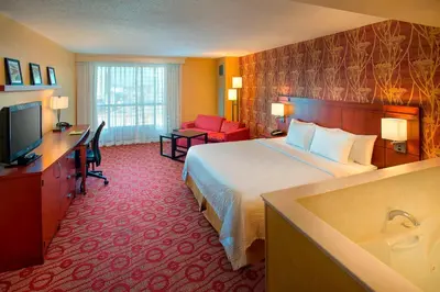 a hotel room with a bed and a desk and a television at Courtyard by Marriott Niagara Falls in Niagara Falls