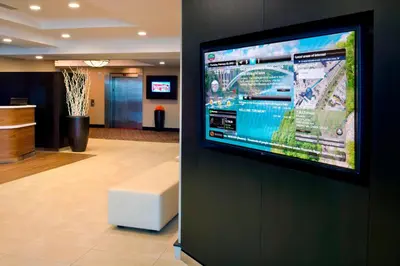 a flat screen tv on a wall in a lobby at Courtyard by Marriott Niagara Falls in Niagara Falls