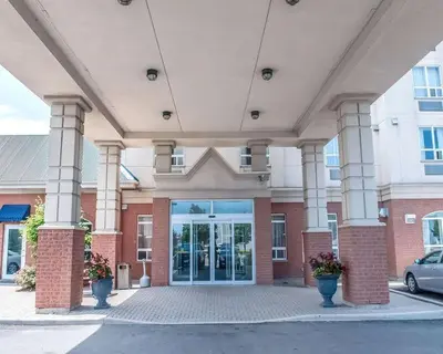 a large building with columns and a glass door at Comfort Inn in Mississauga