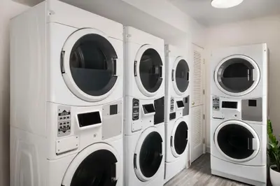 four washers and dryers in a white laundry room at Sonesta ES Suites Toronto Markham in Markham