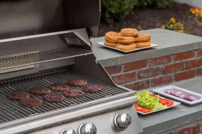 a grill with hamburgers and burgers and a plate of food at Sonesta ES Suites Toronto Markham in Markham