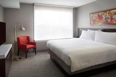 a hotel room with a bed and a red chair at Hilton Garden Inn Toronto Airport West/Mississauga in Mississauga