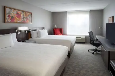 a hotel room with two beds and a desk at Hilton Garden Inn Toronto Airport West/Mississauga in Mississauga
