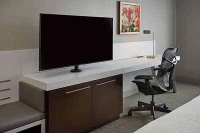 a room with a desk with a tv and a chair at Hilton Garden Inn Toronto Airport West/Mississauga in Mississauga