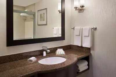 a bathroom with a sink and a mirror and towels at Hilton Garden Inn Toronto Airport West/Mississauga in Mississauga