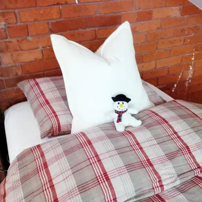 a teddy bear sitting on top of a bed at Picturesque School House Retreat in Meaford