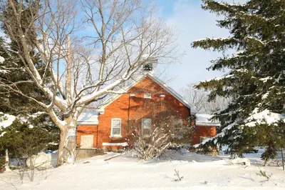 an old red brick house in the snow at Picturesque School House Retreat in Meaford